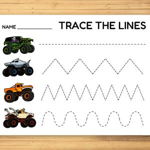 May include: White paper with the text "TRACE THE LINES" and a space for a name. Features illustrations of monster trucks and dotted lines for tracing practice. Includes a green, shark, orange, and white monster truck.