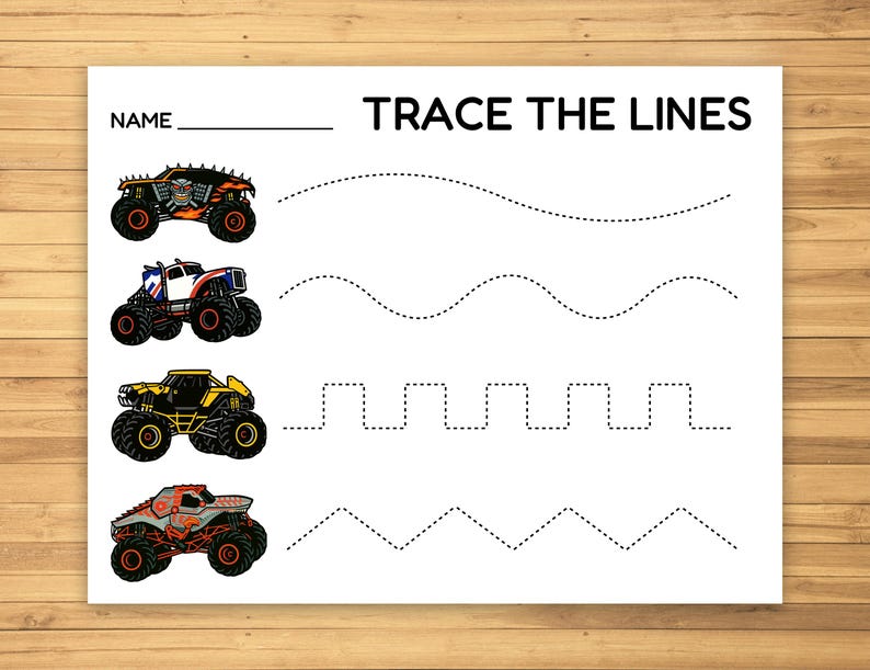 May include: White paper with the text "TRACE THE LINES" and "NAME" above a blank line. Four monster truck illustrations in orange, blue, yellow, and red are on the left, with dotted lines for tracing.