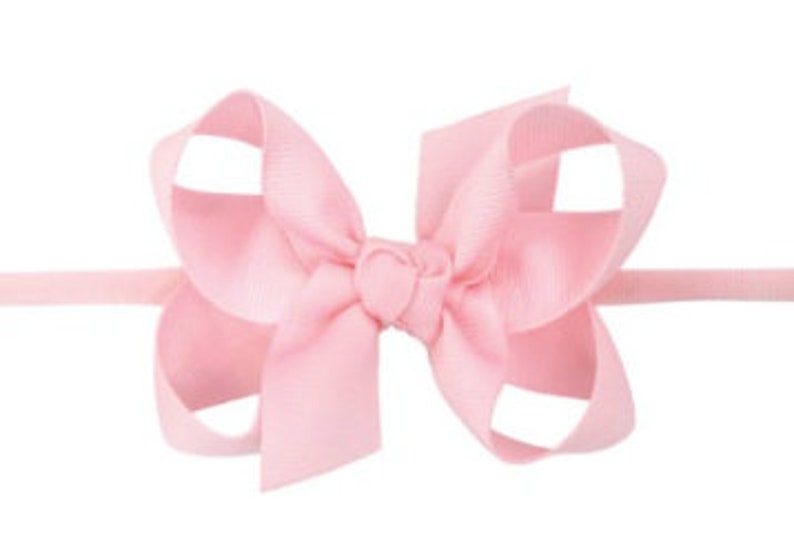 May include: A pink satin bow headband for babies and toddlers. The headband is made with a soft elastic band and a large, double-loop bow.