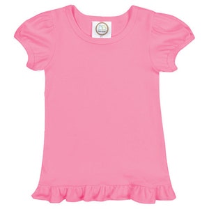 K&ouml;nnte beinhalten: Ein rosa T-Shirt mit kurzen &Auml;rmeln und einem R&uuml;schen-Saum. Das Shirt hat einen runden Ausschnitt und ein kleines Etikett mit den Buchstaben "BB" auf der Vorderseite.