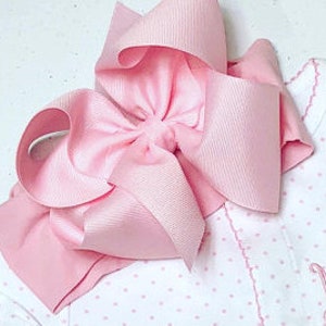 May include: A pink satin bow headband. The headband is made of a soft, stretchy material and is perfect for adding a touch of elegance to any outfit.