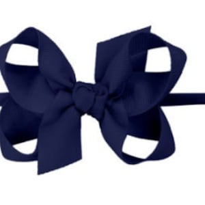 May include: A navy blue hair bow with a simple, classic design. The bow is made from a soft, high-quality ribbon and is perfect for adding a touch of elegance to any outfit.