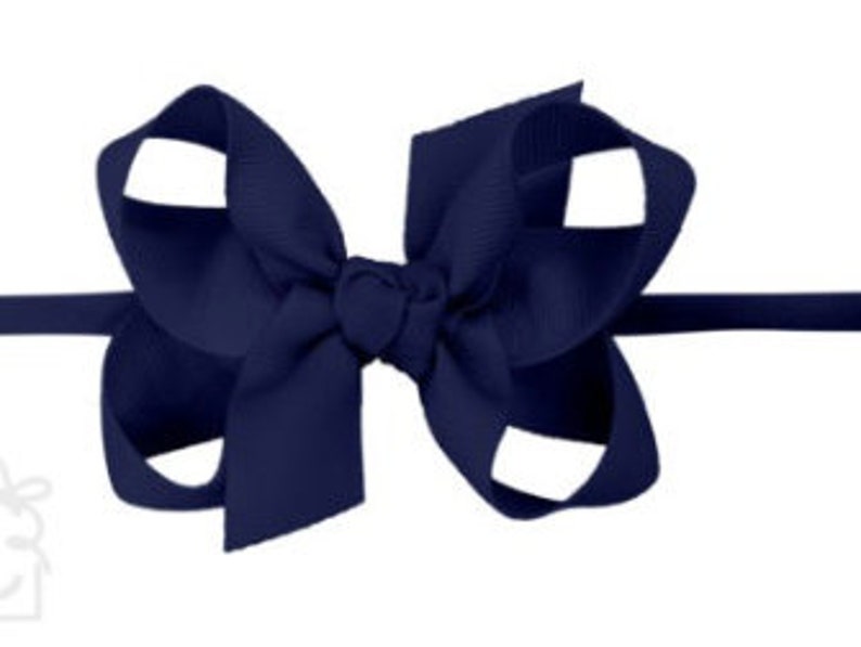 May include: A navy blue hair bow with a simple, classic design. The bow is made from a soft, high-quality ribbon and is perfect for adding a touch of elegance to any outfit.