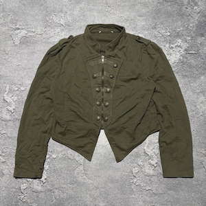 May include: Olive green military-style jacket with a stand-up collar and multiple decorative buttons. The jacket features a zipper closure and shoulder epaulets. The tailored design includes a slightly flared bottom hem, creating a structured silhouette.
