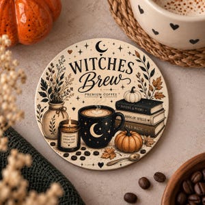 Könnte beinhalten: Ein runder Untersetzer mit dem Text Witches Brew Premium Coffee, einer schwarzen Tasse mit Mondsichel, drei gestapelten Büchern mit den Titeln Potions & Poems, Book of Spells und Wild Magic, einer Kerze, einer Vase und Kürbissen.