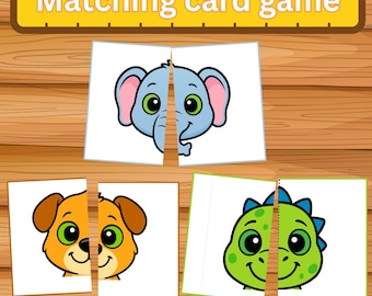 May include: A matching card game with three sets of animal faces: an elephant, a dog, and a dinosaur. The cards are cut in half, ready to be matched. The game is set on a wooden surface, with the words "Matching card game" at the top.
