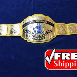 Puede incluir: Un cinturón de campeón de lucha de peso pesado intercontinental dorado y amarillo. El cinturón tiene una correa amarilla con placas doradas y las palabras "Intercontinental Heavyweight Wrestling Champion" en la placa principal. El logotipo de la WWF es visible.