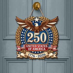 K&ouml;nnte beinhalten: Ein kreisf&ouml;rmiger Wandbehang mit einem Wei&szlig;kopfseeadler mit ausgebreiteten Fl&uuml;geln &uuml;ber der Zahl 250. Das Design umfasst einen blauen Hintergrund mit wei&szlig;en Sternen, goldenen Lorbeerbl&auml;ttern und einem Banner mit UNITED STATES OF AMERICA und 1776-2026.