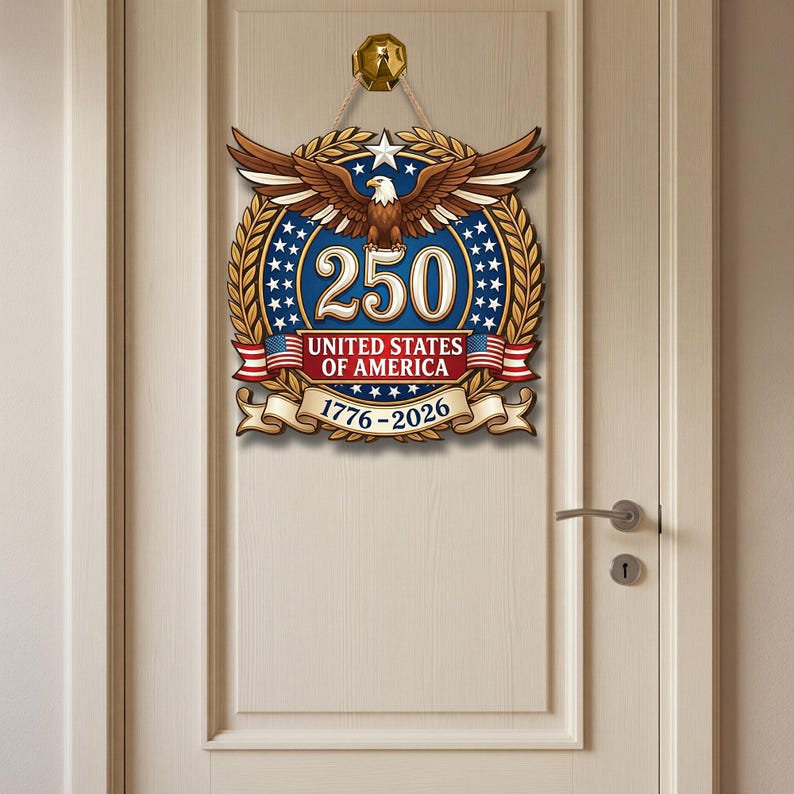 K&ouml;nnte beinhalten: Ein dekorativer Wandbehang mit einem Wei&szlig;kopfseeadler mit ausgebreiteten Fl&uuml;geln &uuml;ber der Zahl 250, dem Text UNITED STATES OF AMERICA und den Jahren 1776-2026. Das Design umfasst einen blauen Hintergrund mit wei&szlig;en Sternen, goldenen Lorbeerbl&auml;ttern und roten Akzenten.