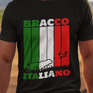 May include: Black t-shirt featuring a graphic design with the text "BRACCO ITALIANO" in green and red, with a white dog silhouette and Italian flag stripes. The shirt is a crew neck style.