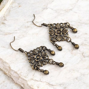 Brincos pendentes em latão envelhecido com visual vintage, estilo floral, com filigrana de flor-de-lis em formato de diamante.