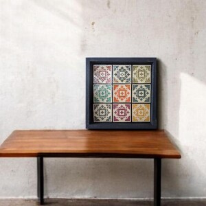 May include: A black framed wall decor with a colorful tile pattern. The tiles are arranged in a 3x3 grid and feature a geometric design with a white background and colorful accents.