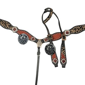 May include: A Western-style horse breast collar with a black leather base, adorned with leopard print accents, red glitter, and silver-toned hardware. Features decorative medallions with a horse head logo and text.