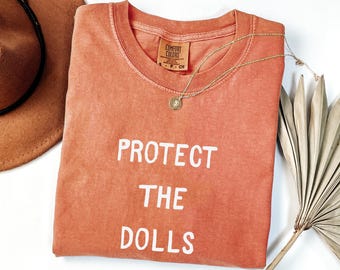 Koszulka Comfort Colors Protect The Dolls, Koszulka na rzecz równości płci, Koszulka Trans Pride, Koszulka aktywisty praw człowieka, Koszulka feministyczna
