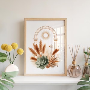 Sage green succulent botanical print framed in light wood set on a bright white fireplace mantel shelf alongside a vase of yellow flowers, glass reed diffusers, and indoor tropical houseplant leaves.