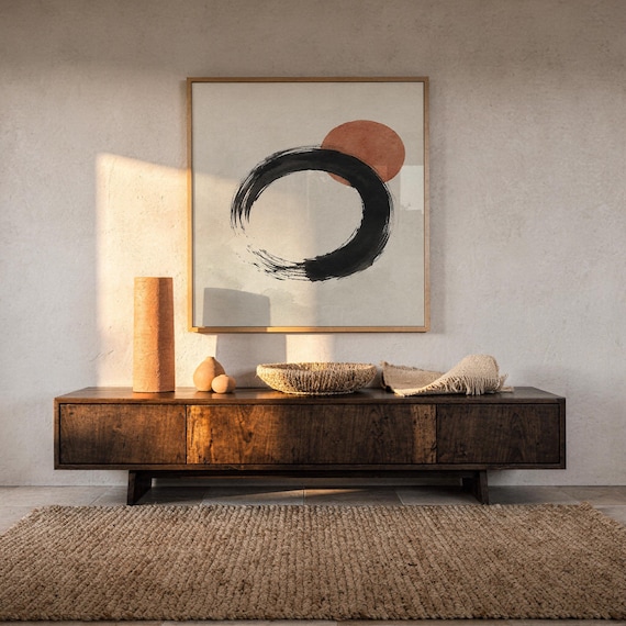 Japanese brushstroke Enso art poster mounted over warm wooden credenza