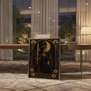 Gothic moon queen wall art print standing on a wooden desk in a home office in warm evening light.