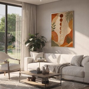 Boho moon phases art print hanging above a white sofa in a living room with garden views.
