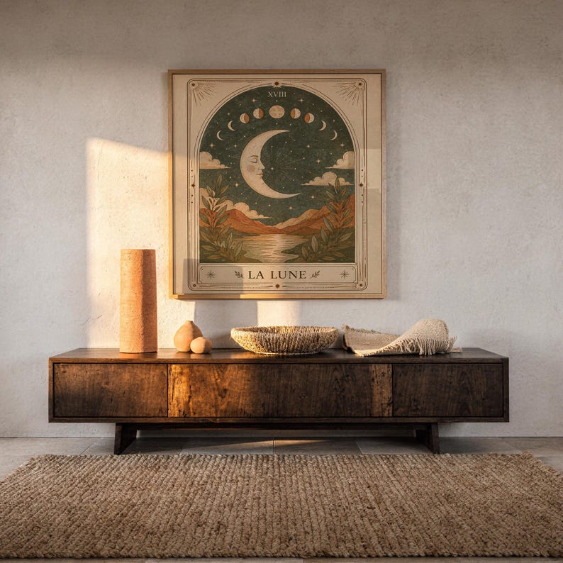Terracotta spiritual moon tarot art framed on dark wooden console table in warm sunlit room.