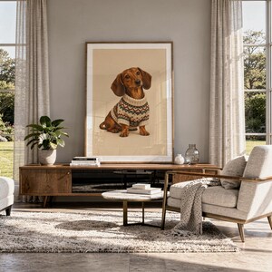Dachshund sweater wall art print hanging above a stone countertop with a fruit bowl in a sunny kitchen.