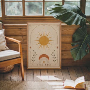 Vintage style celestial sun tarot card poster framed in cozy rustic room with plants