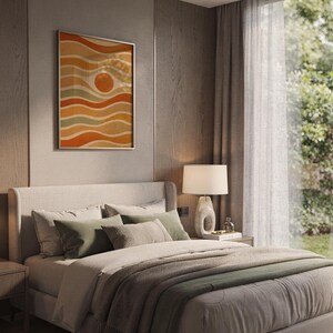 Abstract wavy sun print hanging above a bed with sage green pillows in a calm neutral bedroom.
