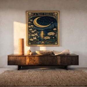 A framed Art Nouveau moon poster hangs on a light wall above a dark wooden console table.