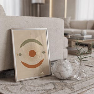 Abstract sun wall art print standing on a countertop in a modern white kitchen.