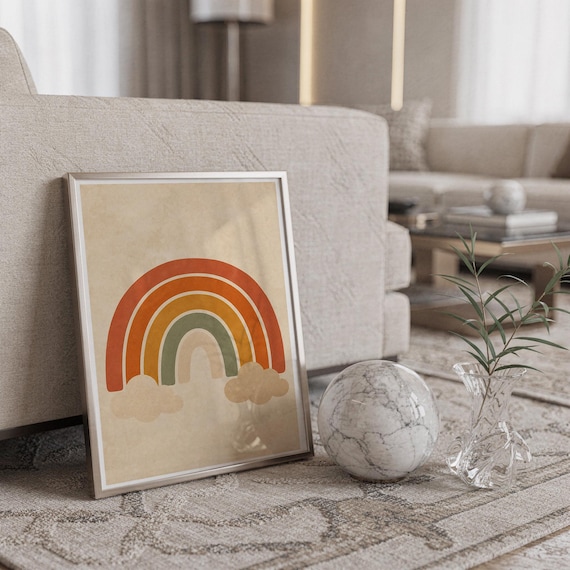 Boho earth tone rainbow print in a silver frame leaning against a sofa beside a decorative marble sphere.