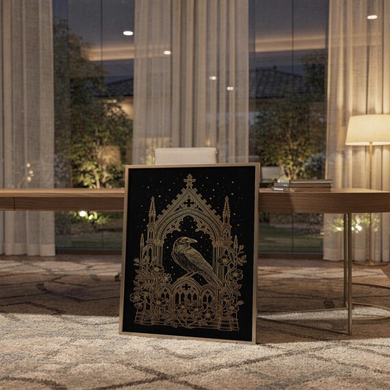 Gothic raven wall art print standing on a wooden desk in a home office in warm evening light.