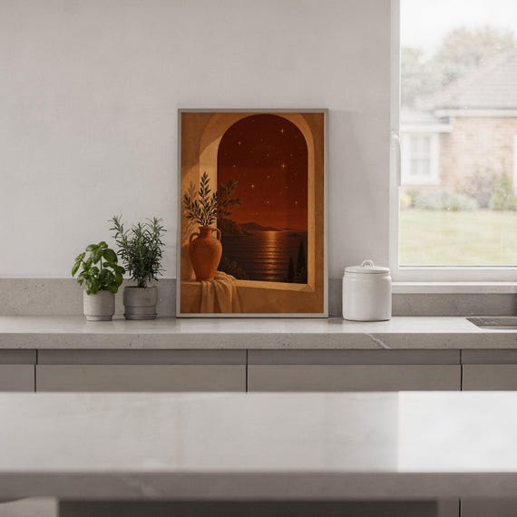Mediterranean night sea wall art print standing on a white kitchen counter beside potted herbs.