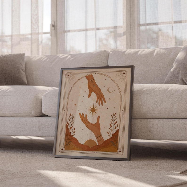Boho magic hands poster framed leaning against sofa in cozy sunlit living room setup.