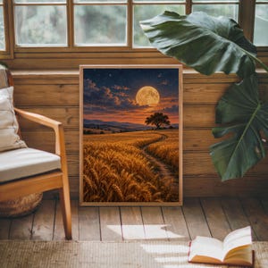 Moon wall art print leaning against warm wood paneling beside a wooden armchair and a monstera plant.