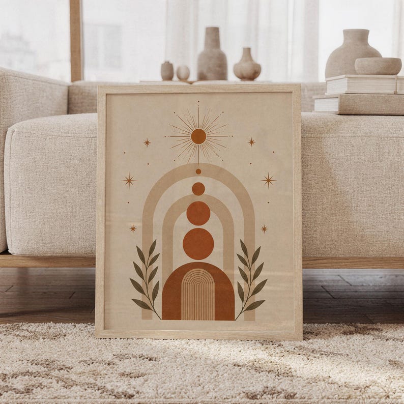 Framed boho geometric arch wall art print leaning against beige sofa in living room with terracotta circles.