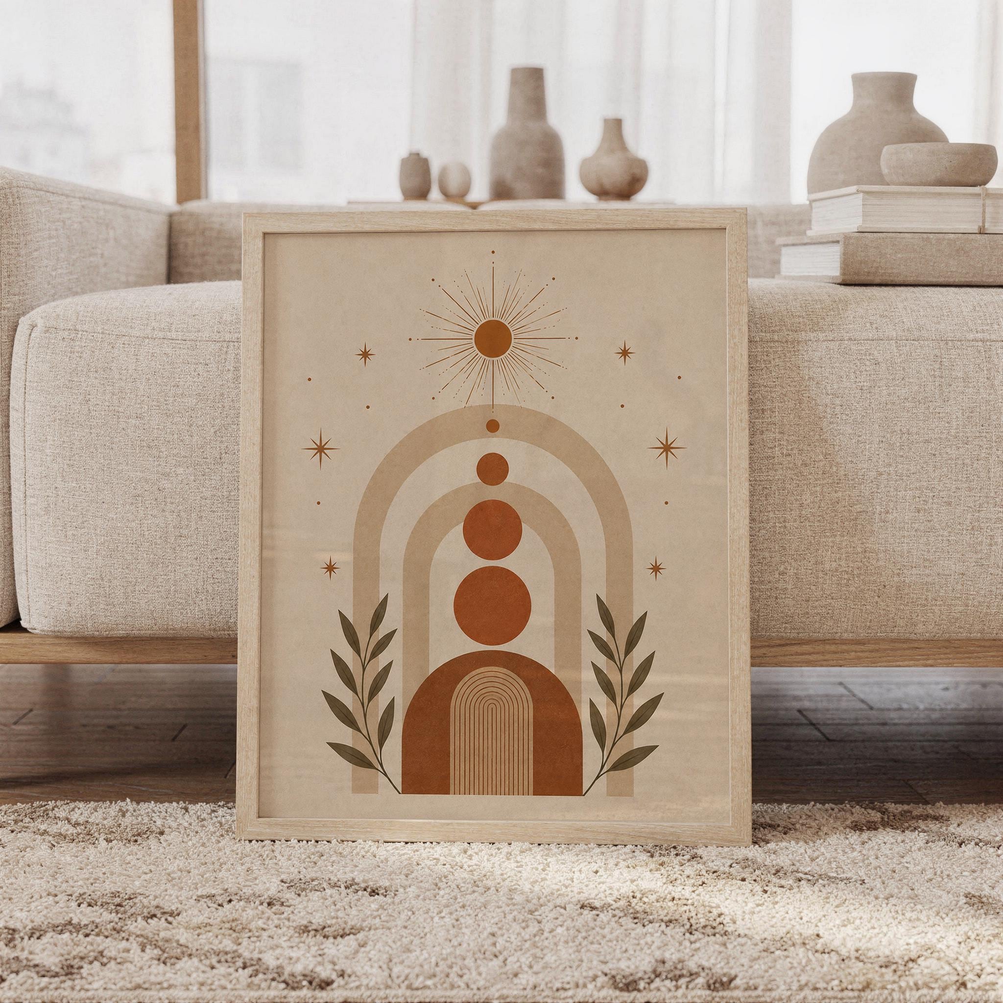 Framed boho geometric arch wall art print leaning against beige sofa in living room with terracotta circles.