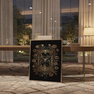 Gothic hourglass wall art print standing on a wooden desk in a home office in warm evening light.