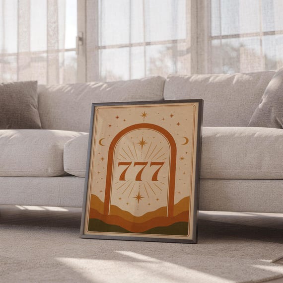 Boho celestial 777 arch poster in a thin frame sitting on the floor in front of a cozy white sofa in a bright living space.