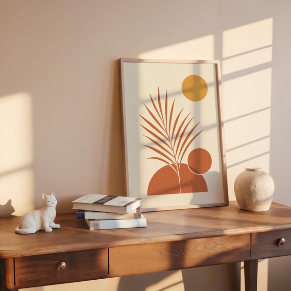Botanical palm leaf print on rustic wooden desk with books and sunlight shadows