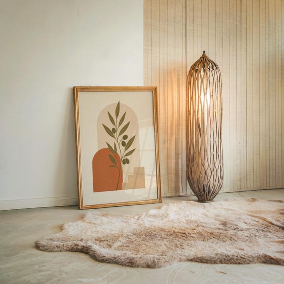 Large framed terracotta arch print on textured floor with tall lamp