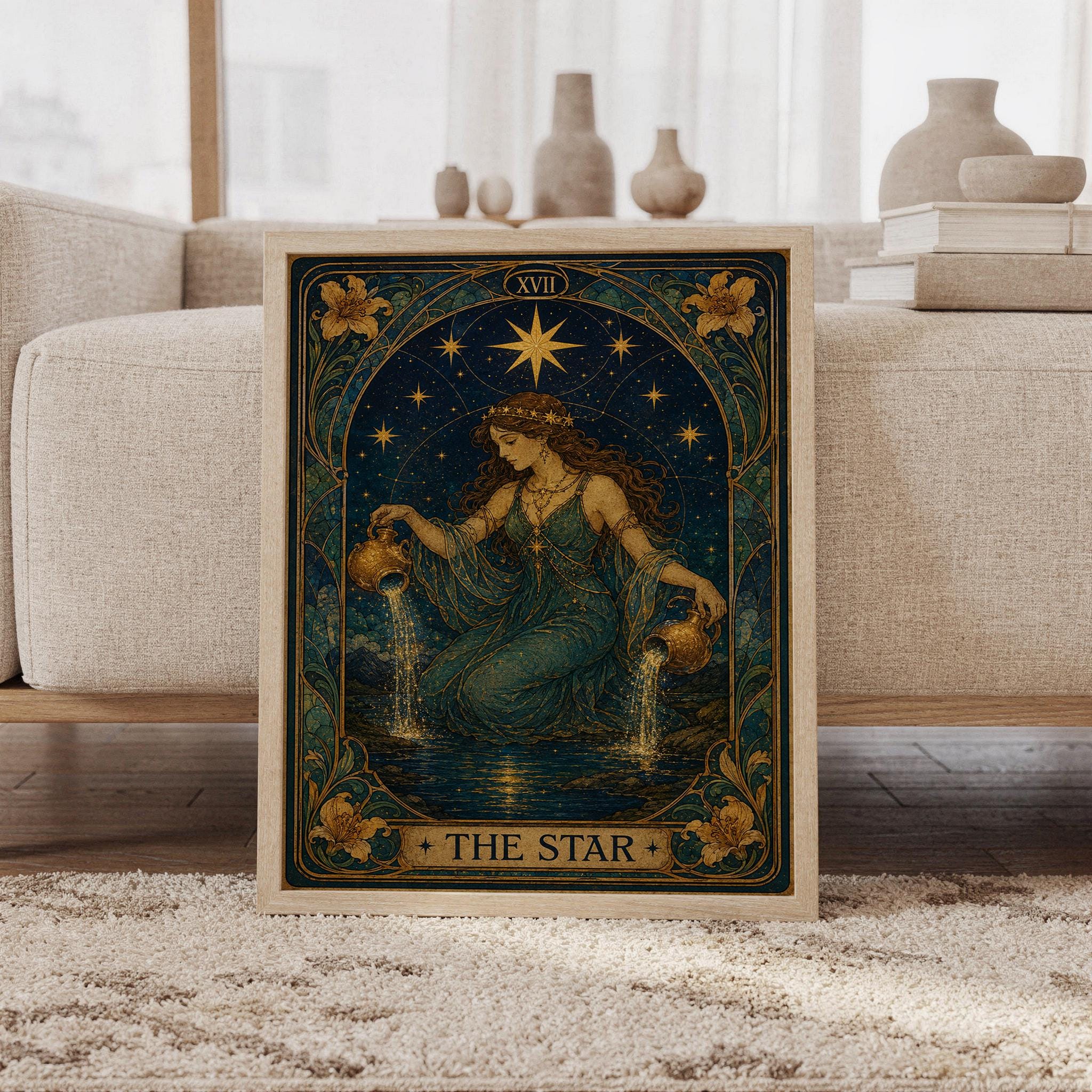 The star tarot card wall art print featuring deep navy, teal, and antique gold tones, a celestial goddess pouring from ornate vessels, radiant stars, lilies, and an Art Nouveau-inspired frame, framed and leaning against a beige sofa on a textured rug in a bright Scandinavian living room.