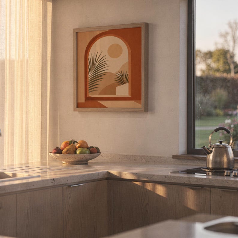 Terracotta arch palm art print framed on kitchen wall illuminated by warm sunset light.