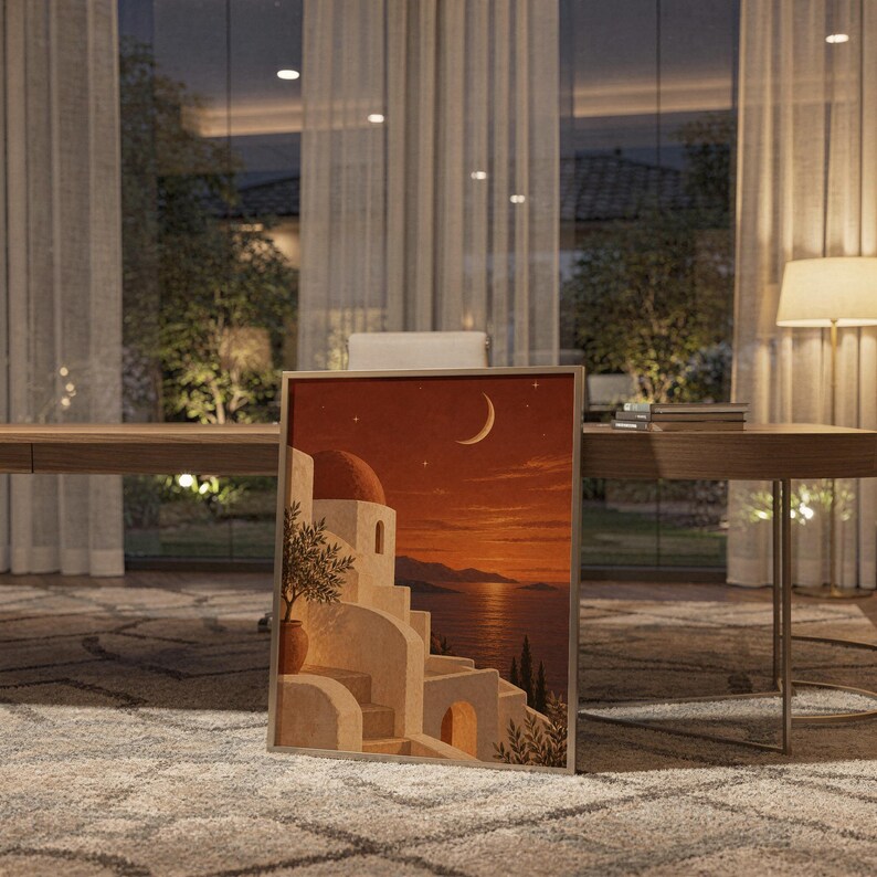 Mediterranean moonlit coastal wall art print standing on a wooden desk in a home office in warm evening light.