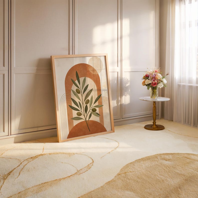 Warm neutral olive branch art resting on floor in bright open room