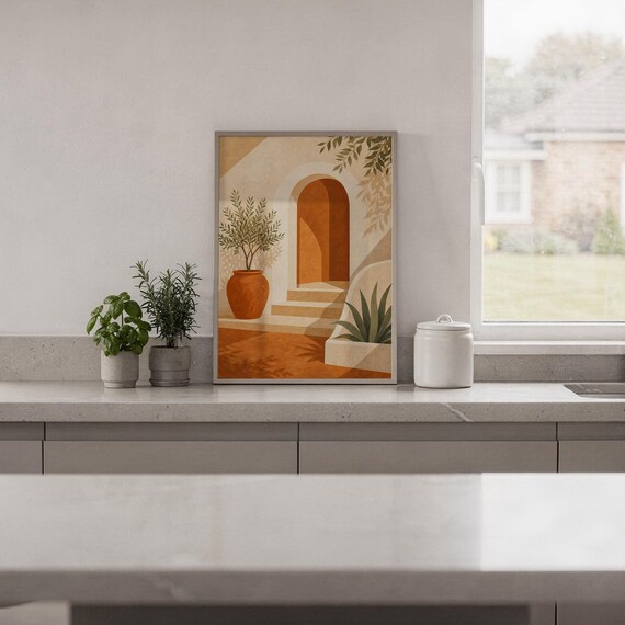 Mediterranean terracotta stairway arch print standing on a white kitchen counter beside potted herbs.