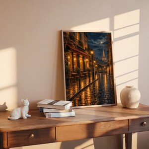 Paris eiffel tower wall art print leaning on a wooden desk against a warm beige wall in soft window sunlight.