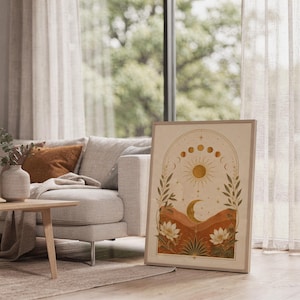 Celestial sun and moon wall art print standing on a white kitchen counter beside potted herbs.