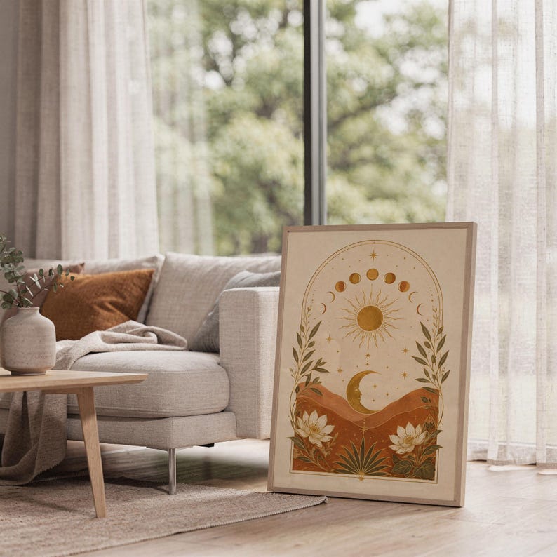 Celestial sun and moon wall art print standing on a white kitchen counter beside potted herbs.