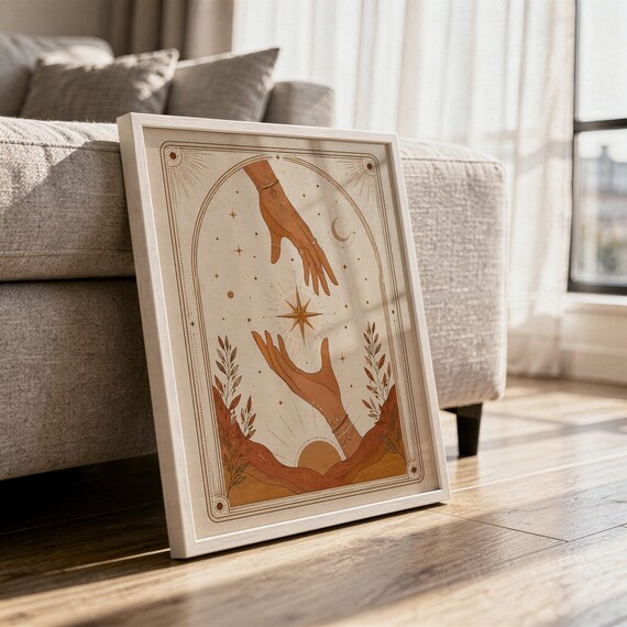 Terracotta celestial hands print framed on hardwood floor in sunlit living room decor.