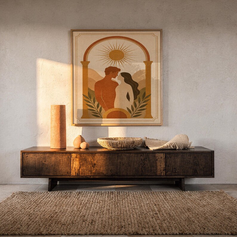 Framed minimalist sun and couple poster hanging above a dark wood sideboard console in a warm, ambient living room interior.