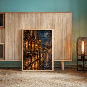 Paris eiffel tower wall art print leaning against a wooden cabinet by a teal wall beside a glowing floor lamp.